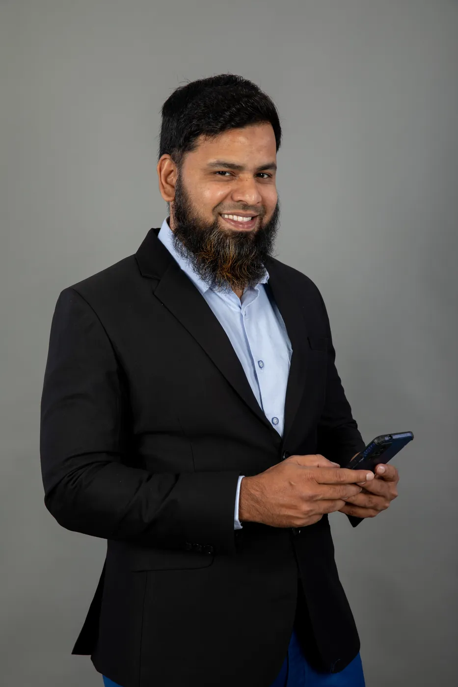 Abdul Lathif smiling, phone in hand